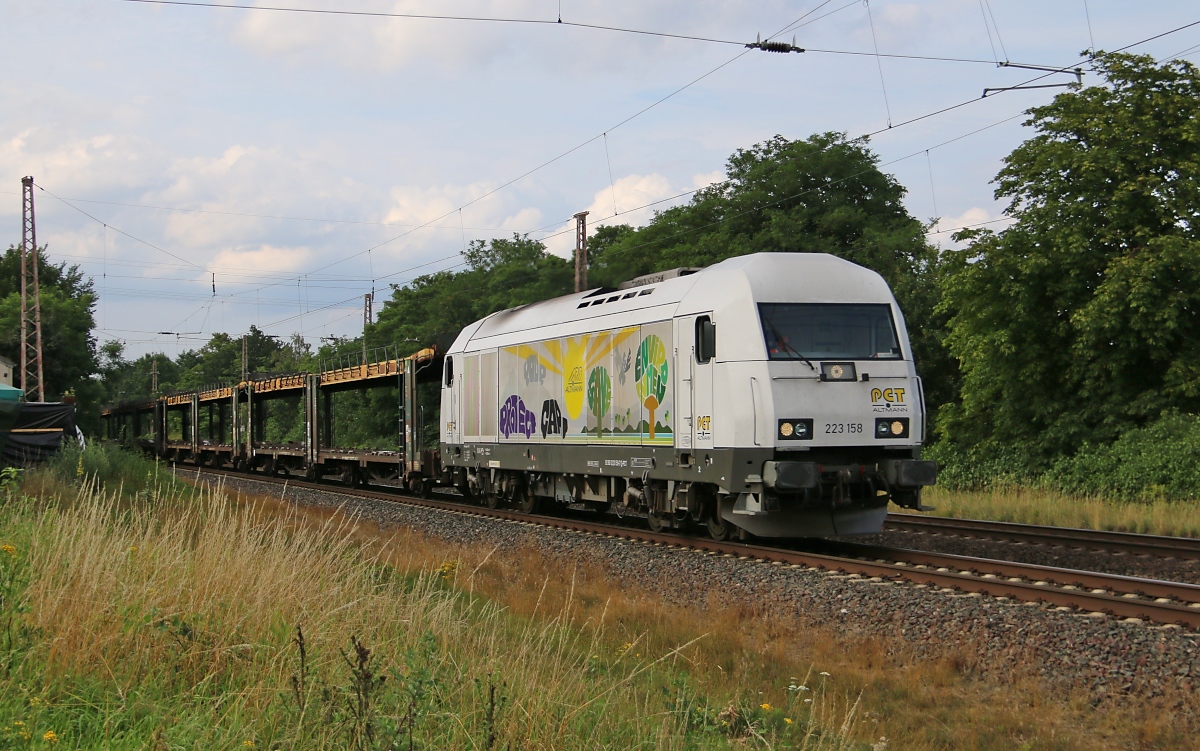 223 158-7 mit leeren Autotransportwagen in Fahrtrichtung Eystrup. Aufgenommen bei Wahnebergen am 23.07.2015.