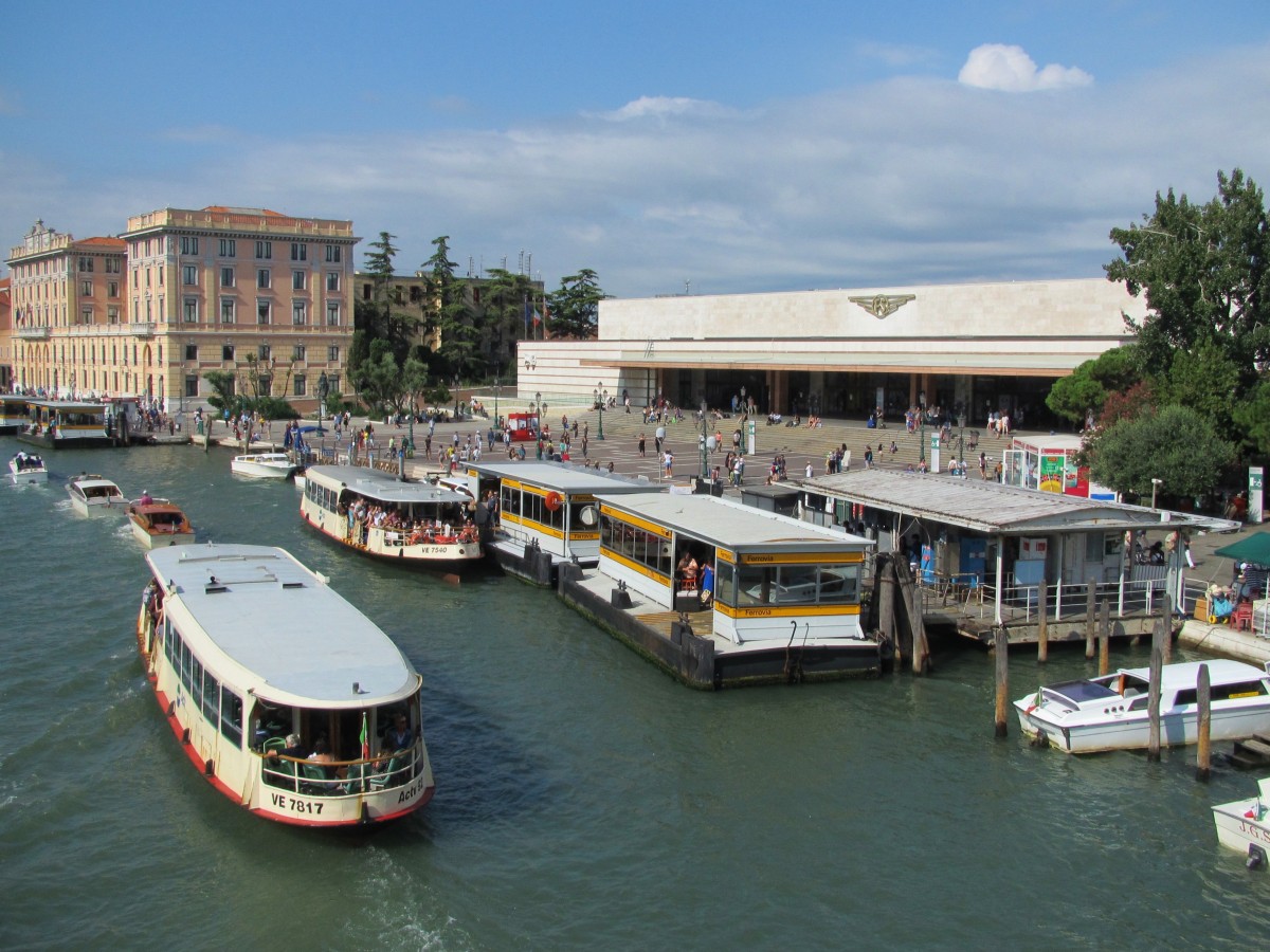 22.8.2014 10:20 Bahnhof Venezia Santa Lucia; der wohl wichtigste Ankunftspunkt für Touristen, die Venedig besichtigen wollen. Benannt wurde er nach der Kirche, die früher an an der selben Stelle stand. Im Vordergrund der Canal Grande mit Anlegestelle für Vaporetti.