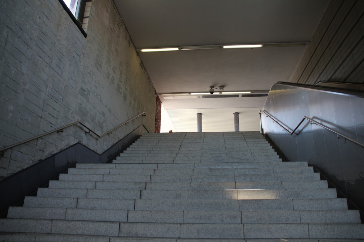 22.8.2015 Berlin-Gesundbrunnen; Treppenaufgang mit abgefallenden / entfernten Fliesen am Südende, Baujahr 2005. Damit sowas nicht passiert, hat man in Südkreuz gleich nur nackte Betonwände gestellt.  Kurioses  trifft es nicht ganz - die Kategorie  Bedauerliches  gibt es jedoch noch nicht.
