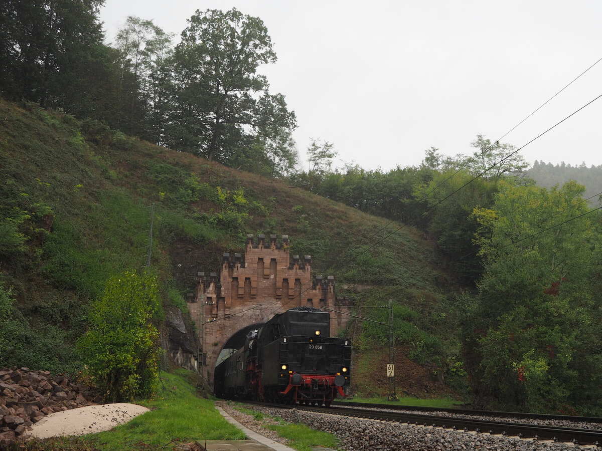 23 058 fährt mit einem Dampfzug Tender voraus durch das Südportal des Eisenkehl-Tunnels zw. Frankenstein und Weidenthal im strömenden Regen Richtung Neusstadt/W.
Anlass meiner Reise war das 175-jährige Jubiläum der Eisenbahn in der Südpfalz.

Weidenthal, der 01.10.2022