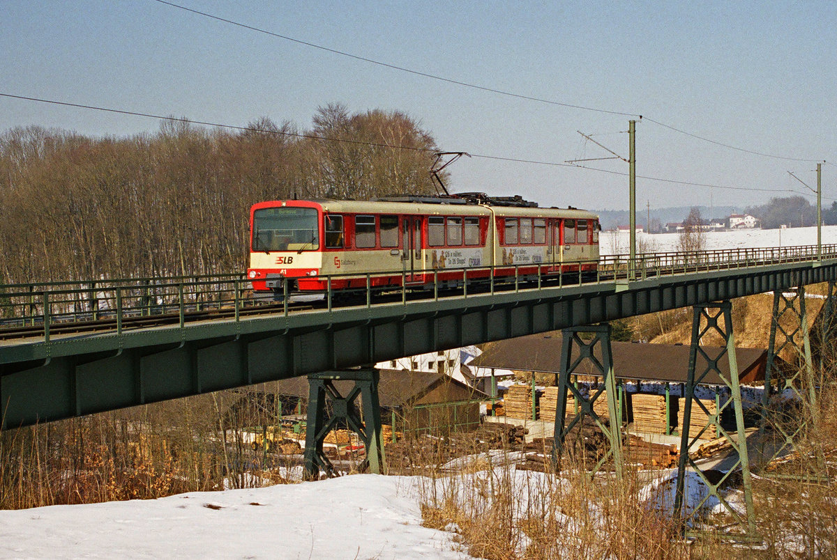 23. Februar 2003, viel Schnee liegt nicht im Salzburger Land. ET 41 der Salzburger Lokalbahn auf der Brücke bei St. Georgen.