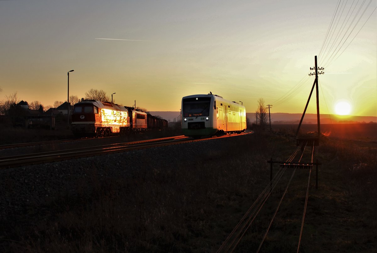 231 012 und 155 110 (WFL) standen am 23.01.20 mit einem Holzzug im Sonnenuntergang von Triptis. Der VT 331 (EBx 80862) fuhr an dem Zug vorbei.