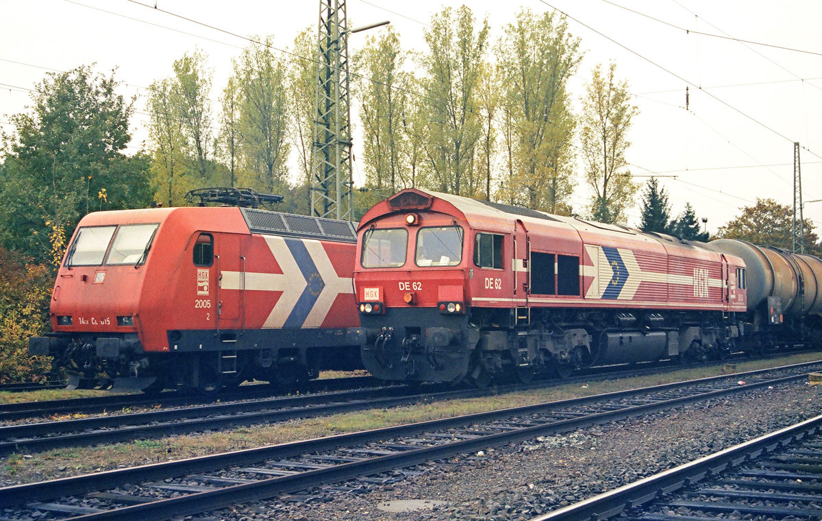 23.10.2006, Bhf. Hochstadt-Marktzeuln in Oberfranken. Lokomotiven 145 CL 015 u. DE 62 der Häfen und Güterverkehr Köln. Letztere ist eine  Class 66  (Type EMD JT42CWR(M). Was die Loks der unterschiedlichen Traktionsformen mit den Kesselwagen angestellt haben, kann ich nicht mehr nachvollziehen. Fakt ist, dass im hiesigen Bahnhof die nicht elektrifizierte Strecke von Hof/Bayreuth auf die von Saalfeld in Richtung Bamberg führende elektrifizierte trifft.