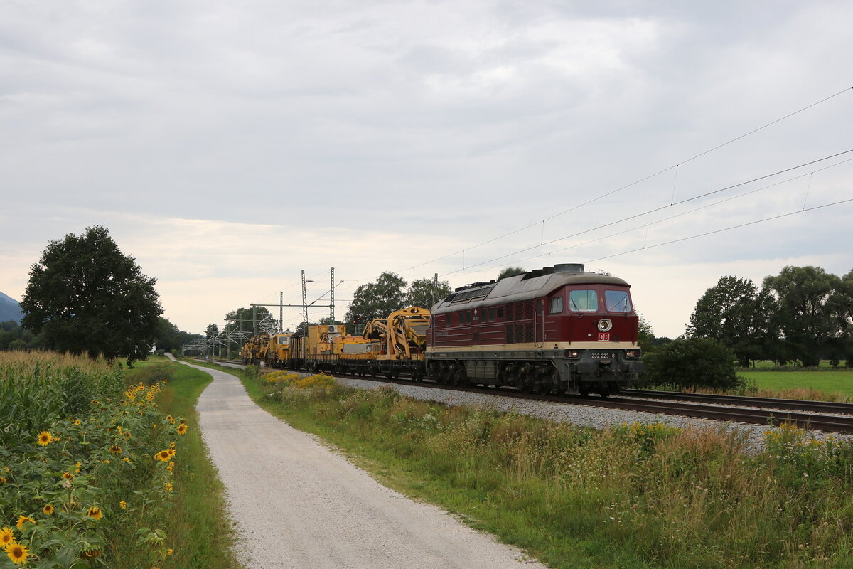 232 223 war am 22. August 2021 mit einem Bauzug bei Übersee am Chiemsee in Richtung Freilassing unterwegs.