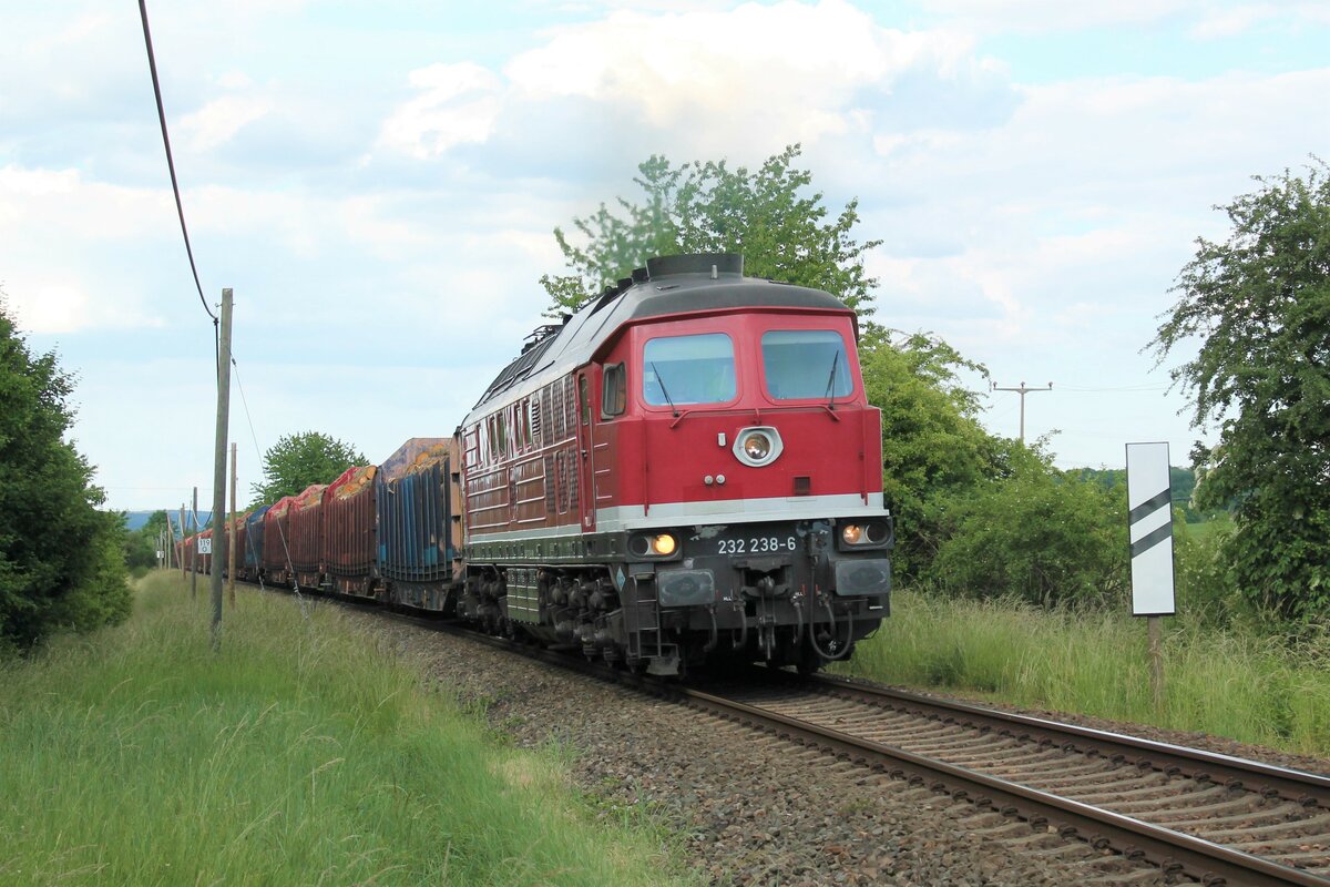 232 238-6 der WFL mit einem Holzzug aus Triptis am 10.6.2022 in der Einfahrt nach Pößneck. Am Zugende lief noch 155 222 (ebenfalls WFL) mit.