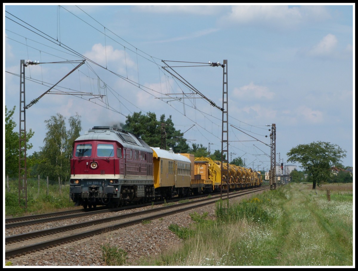 232 550 zieht am 1.8.14 einen Bauzug über die Rheinbahn in Richtung Graben - Neudorf zur Großbaustelle.
Festgehalten bei Wiesental.