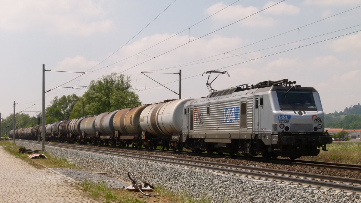 24.05.2012, Ein Kesselwagenzug in Richtung Saalfeld fährt wegen Bauarbeiten im Bereich des Haltepunktes Küps auf dem  falschen Gleis . Zugpferd ist die 3-System-Lok Alstom-Prima 37 025 der SNCF, augenscheinlich unter Regie der HSL-Logistik.