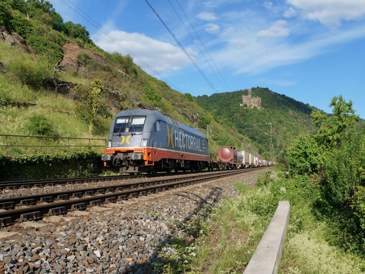 242.531 von Hectorrail zog am 30.5.2020 einen Containerzug bei Wellmich, vor der Kulisse der Burg Maus, durch das Rheintal.