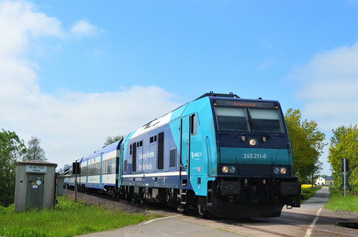 245 211 Beförderte am 30.05.21 den RE6 (11012) von Hamburg-Altona nach Westerland (Sylt).
Der nächste Halt des Zuges ist Heide (Holst.). DAS Foto entstand am BÜ Hove in Wilster.