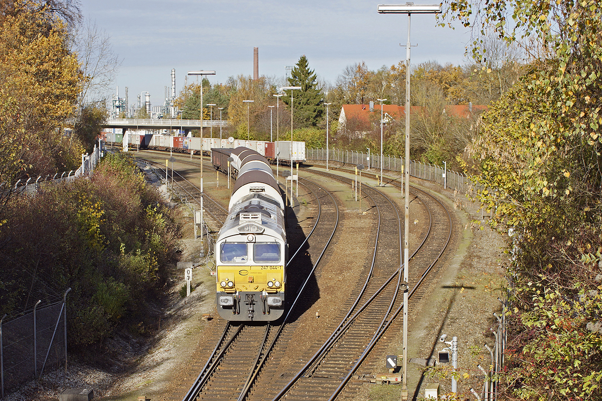 247 044-1 hat vor wenigen Minuten einen langen Containerzug (im Hintergrund) aus Richtung Mühldorf in die Einfahrgruppe des Werkbahnhofs des Wacker Werkes Burghausen gezogen. Auf dem Weg zurück zieht sie einen kurzen Zug aus wenigen Kessel- und Rolldachwagen. 08.11.2013

Hersteller (mechanisch): GM-EMD
Fabriknummer: 20068864-044
Indienststellung: 2008
ursprüngl. Fahrzeugnr. 266 444-9
Fahrzeugnr. z.Z.d. Aufnahme: 92 80 1266 444-9 D-DB
Betreibernr. z.Z.d. Aufnahme: 247 044-1
Radsatzfolge: Co'Co'
Vmax (km/h): 120
Leistung (kW): 2.420
Anfahrzugkraft (kN): 467
Dienstmasse (t): 130
Radsatzfahrmasse max. (t): 22
LüP (mm): 21.349