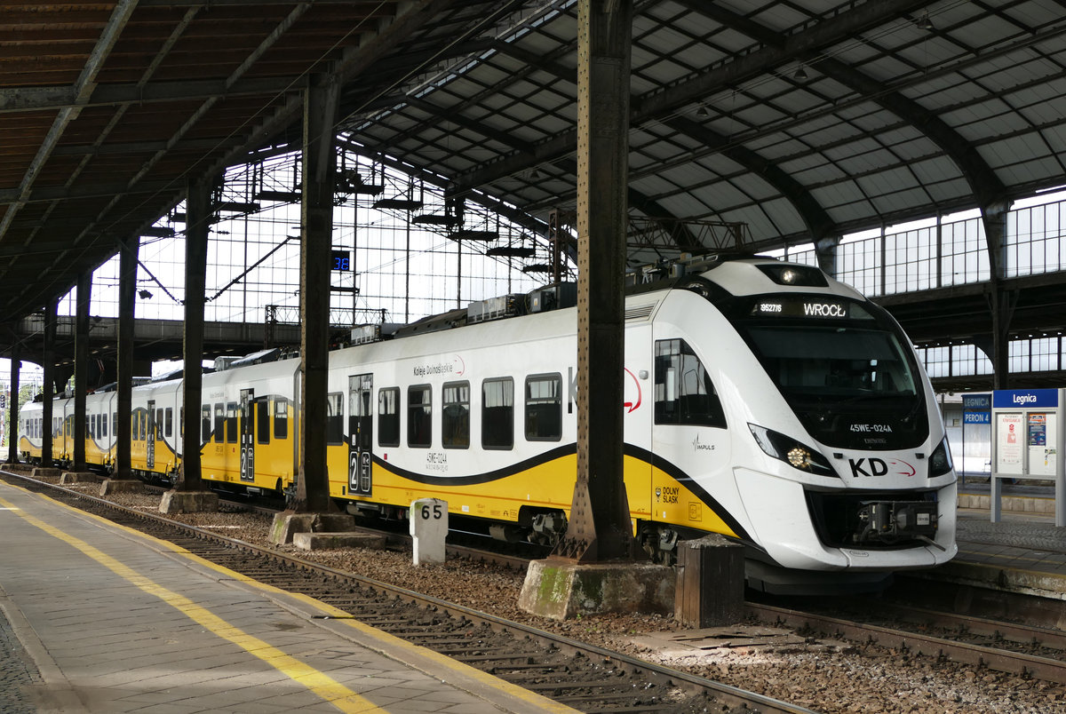 26.09.2018, Auf dem Liegnitzer Bahnhof. Am Bahnsteig 2 in der großen Halle stand der abfahrbereite Tw EN98 024 nach Wroclaw (KD 69527/6).  Gute Fahrt  für den  Impuls  der Niederschlesischen Eisenbahn. Dabei handelt es sich um einen Elektrotriebwagen der polnischen Firma Newag für den Regionalverkehr. Er wird seit 2011 hergestellt. Die Variante 45WE hat 5 Wagen und eine Leistung von 2000 kW. 