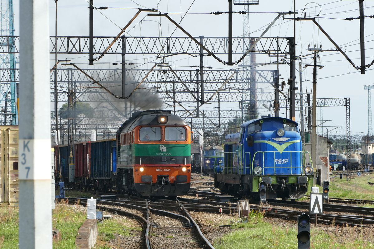 26.09.2018, Polen, Auf dem Liegnitzer Bahnhof gab es recht unterhaltsamen Betrieb. Wen juckt das bisschen Ruß? - Eine M62 der privaten Bahngesellschaft PTM bringt einen Ganzzug in den nahen metallurgischen Großbetrieb. Leider stand ich auf der falschen Seite (aber nicht auf dem Gleis! Das schwenkt vor dem Bahnsteigende nach rechts ab).