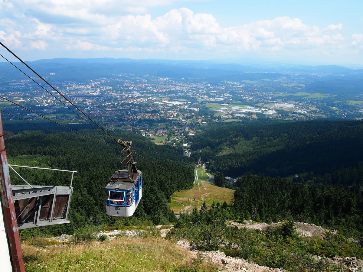 ČD Seilbahn auf Jested. Die Unterstation der Seilbahn befindet sich in Liberec - Horní Hanychov nicht weit von der Endstation vom Stadtmassenverkehr und die Oberstation ist auf dem Gipfel des Bergs Ještěd beim Fernsehsender mit einem Hotel.Ansicht von Liberec von Ještěd am 7.8.2014