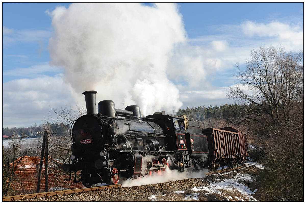ČSD 434 2186 (kkStB 170.323) vom Depot Vršovice mit ihrem Plangüterzug von Praha-Vršovice nach Dobříš am 6.2.2014 vor Mníšek pod Brdy.