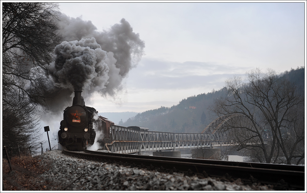 ČSD 434 2186 (kkStB 170.323) vom Depot Vršovice mit ihrem Plangüterzug von Praha-Vršovice nach Dobříš am 6.2.2014 bei der Querung der Moldau kurz vor Měchenice.