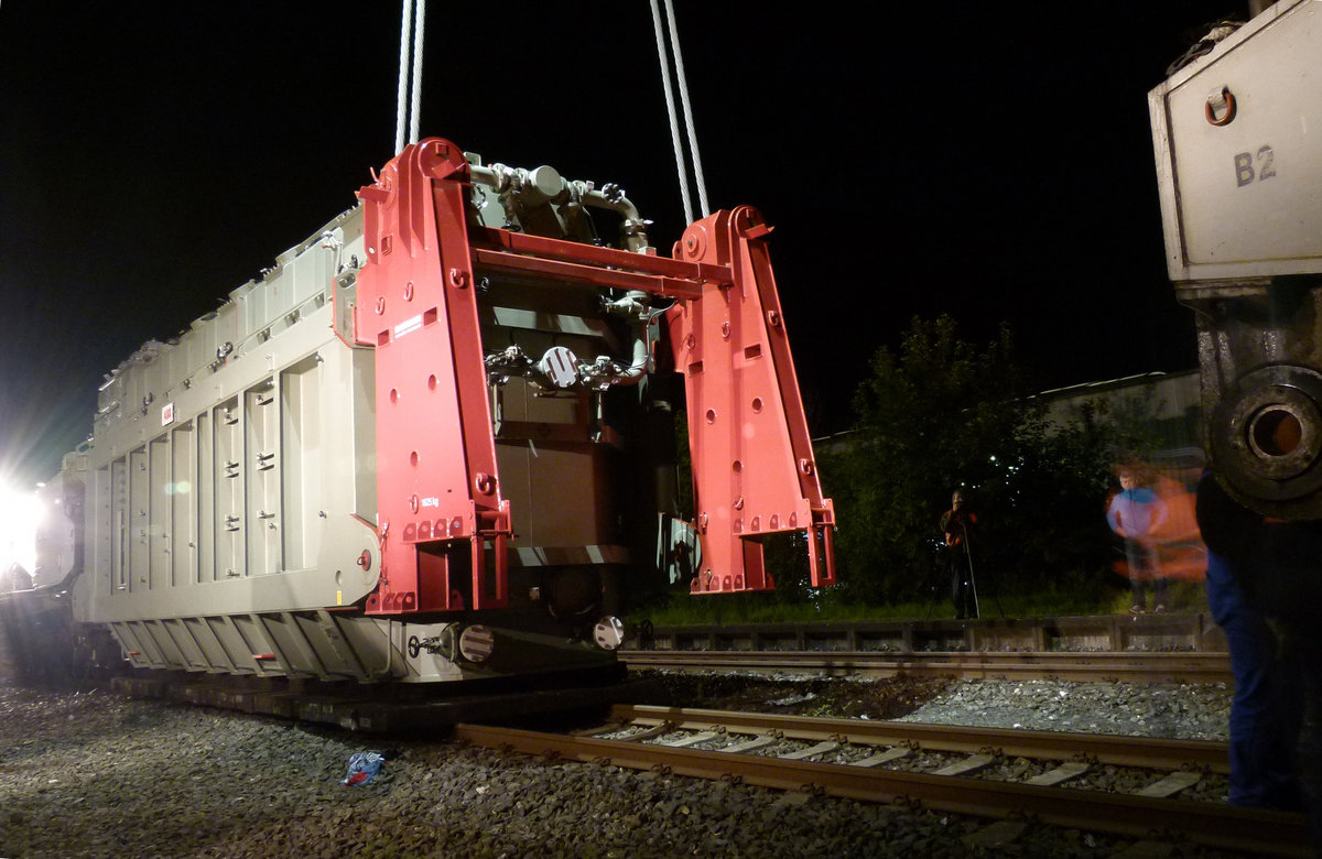 27. Juni 2012 01:25 Uhr, Im Bahnhof Burgkunstadt wird ein Großtransformator mit einer Masse von 232 Tonnen (Pressemitteilung Tennet) vom Tragschnabelwagen Uaai 8680 996 0404-3 der NCS-GmbH Hanau auf einen Straßentransporter umgeladen. Während die Eisenbahner ihren Uaai im Dunklen in den Transportzustand zusammenschieben, wird die Last jetzt von zwei Autokränen zum Staßentransporter manövriert. 