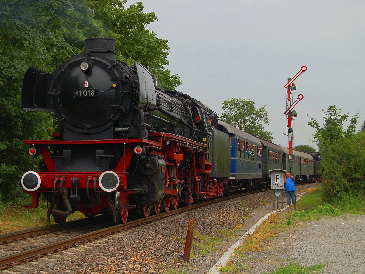 29.05.2014, zweiter Tag von insgesamt fünf des Dampfspektakels 2014 in der Region Pfalz-Rhein-Neckar. Nicht nur das über den ganzen Tag bescheidene Wetter, sondern auch einige eigentlich brauchbare Fotostellen, an Strecken welche so schon kaum zugänglich sind, sorgten unter den Fotographen für Unmut und einige Diskussionen: Bauzäune + Container, Bahnbaustellen, Vegetation und Dampfzüge die auf bestimmten Strecken zum Großteil nur Tender voraus fuhren. Dies war auch hier fast zum Problem geworden, da die eigentliche Fotostelle weiter vorne durch eine solche Baustelle blockiert und nicht zugänglich war. Aber das Alles konnte mich nicht am Fotographieren, wie auch meinen Vater weiter vorne im Bild nicht am Filmen, hindern. Hier ist 41 018 am Zugschluss des Sonderzuges von Bensheim nach Worms Hbf, am Formsiganl kurz vor dem (unteren) Bahnhof Bürstadt, zu sehen. Zuglok war 41 360. 29.05.2014