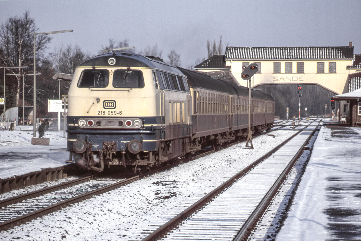 30.01.1993 - Sande Bahnhof. DB Baureihe 216 059 vor E7326 von Wilhelmshaven nach Osnabrück. Die Fußgängerbrücke ist mittlerweile abgerissen worden. Die Gleise werden zur Zeit im Bahnhof Sande neu verlegt. (Bild vom Dia)