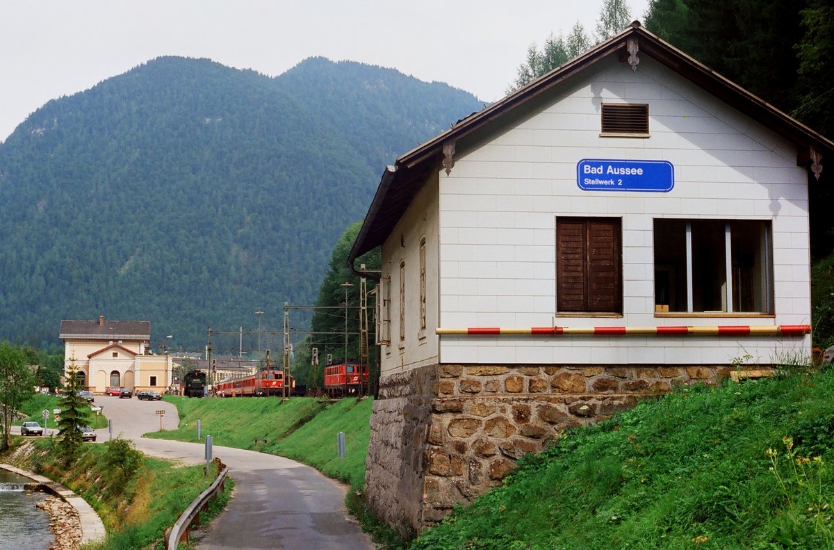 30.08.1992, Österreich,	Bahnhof Bad Aussee, Ansicht von der Straße. Im Hintergrund mehrere Fahrzeuge, links die grüne 1245 005, in der Mitte 1042 019 mit einem planmäßigen Zug nach Attnang-Puchheim. Rechts rangiert 1041 024.