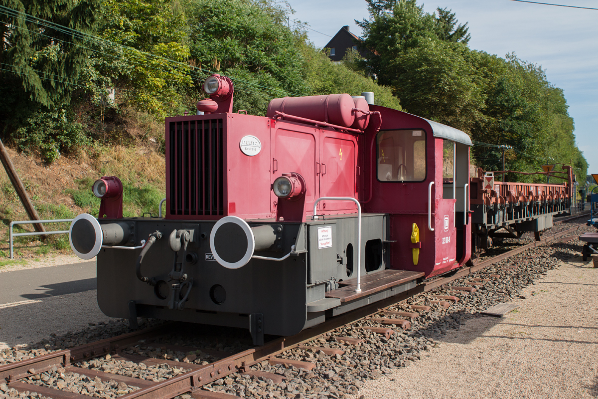 323 100-8 mit einem Flachwagen ist in Pronsfeld in der Eifel als Denkmals aufgestellt. (26.08.15)