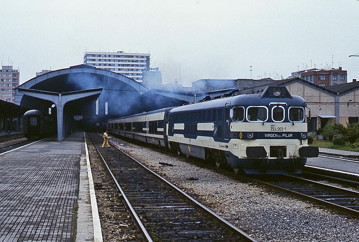 354-005-1  Virgin del Pilar  beginnt im April 1984 ihre Fahrt von La Coruna nach Madrid. Krauss-Maffei lieferte 1983/84 acht Lokomotiven dieser Bazreuhe für die Talgo IV-Züge. Sie sind eine Weiterentwicklung der Baureihe 352, die technisch auf der DB V 200 basiert.
