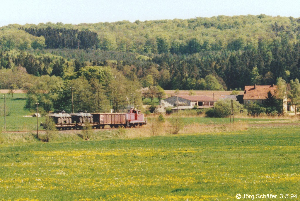 360 241 war am 3.5.94 mit ihrem Güterzug nach Bamberg zwischen Manndorf und Reckendorf unterwegs. Am Schluss zwei Panzer aus der Eberner Balthasar-Neumann-Kaserne.