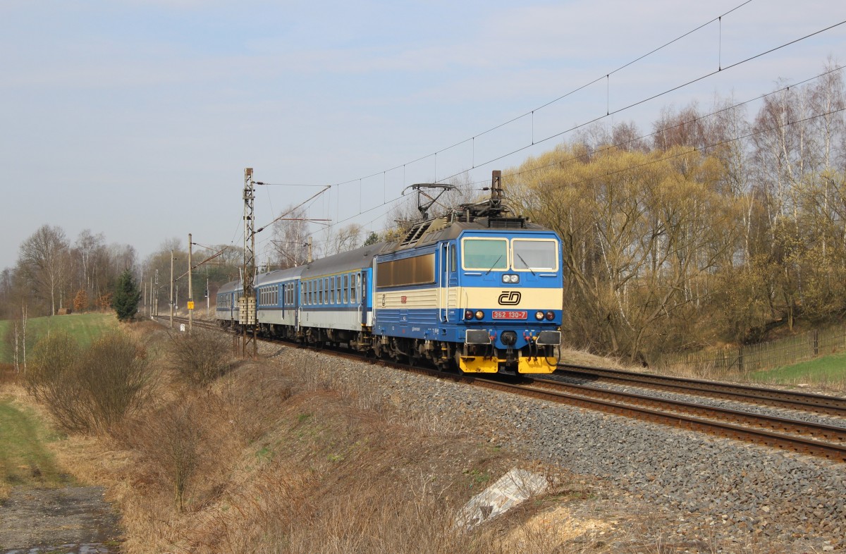 362 130 fährt am 11.04.15 mit einem Schnellzug durch Chotikov.