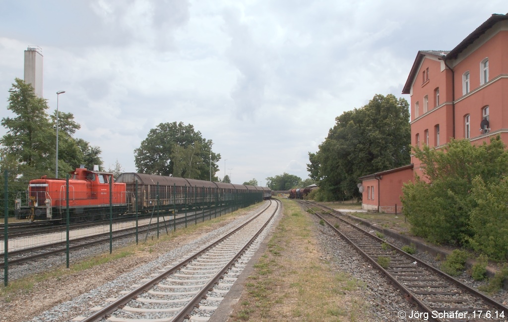 363 661 rangierte am 17.6.14 in Wassertrüdingen Güterwagen in den Gleisanschluss der Firma Schwarzkopf. Rechts das Empfangsgebäude, das schon lange nicht mehr betrieblich besetzt ist und inzwischen als Ausländerwohnheim dient.