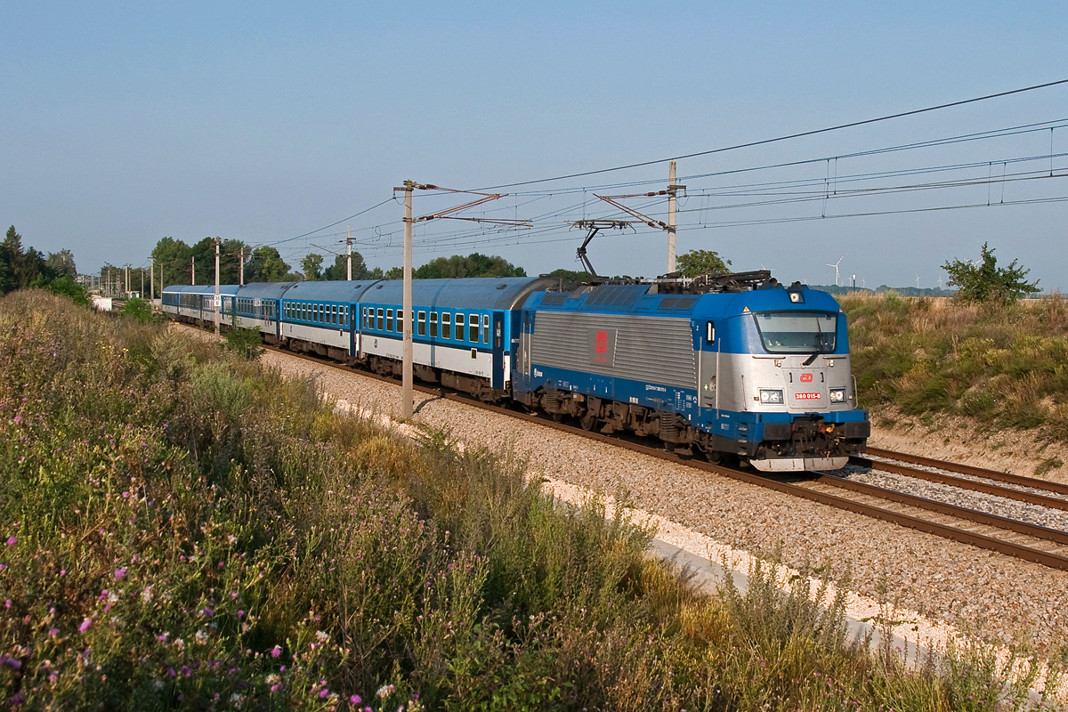 380 015 ist mit EC 78 von Wien Praterstern nach Prag in der Morgensonne unterwegs. Tallesbrunn, am 03.08.2014.