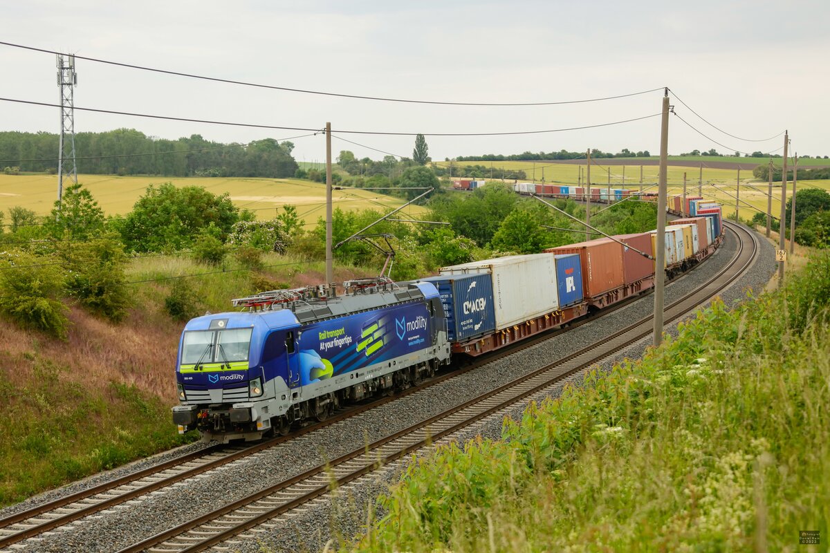 383 425  modility  mit Containerzug in Ovelgünne, Juni 2023.