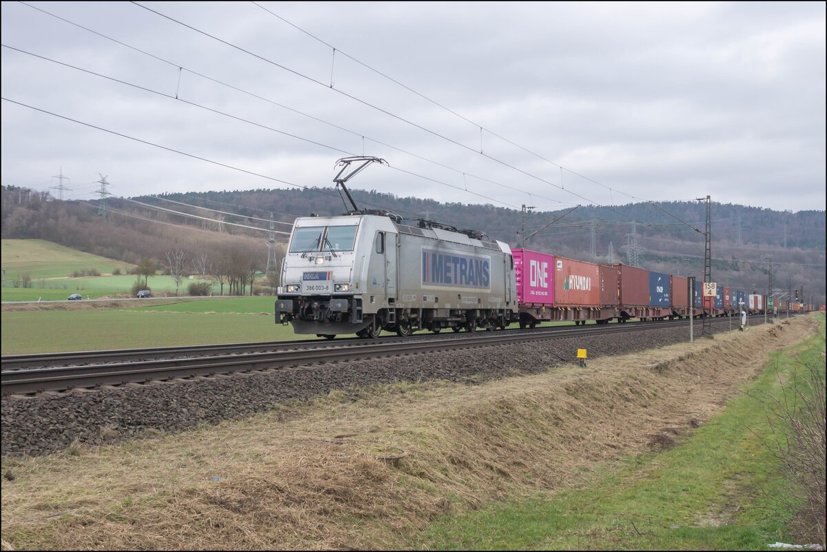 386 003-8 zu sehen am 21.02.2024 mit einem Containerzug bei Reilos.