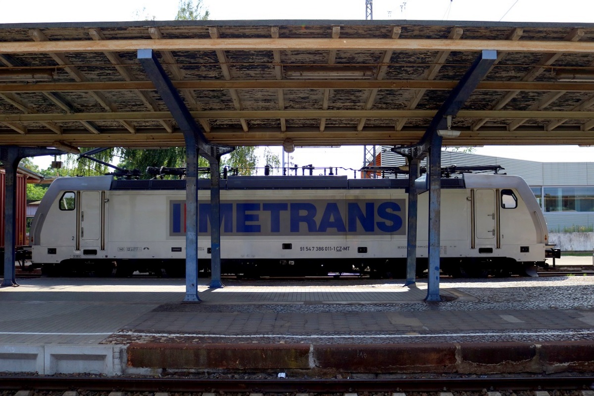 386 011-1 Metrans als Containerzug durchfährt den Bahnhof Falkenberg(Elster). Der Fotograf befand sich leider zur falschen Zeit am falschen Ort; daher ein Schnappschuss durch die Überdachung. [8.7.2017 - 16:59 Uhr]