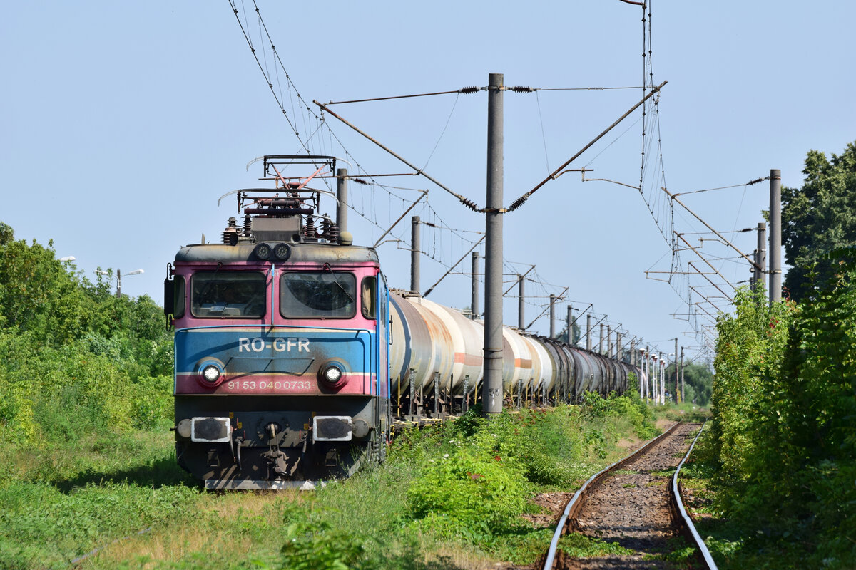 400 733-8 hat einen Kesselwagenzug nach Ploiesti Nord gebracht und wartet nun den Regionalzug ab um wieder solo zur�ck Richtung Ploiesti Sud fahren zu k�nnen. Aufgenommen vom Bahn�bergang.

Ploiesti Nord 27.07.2026