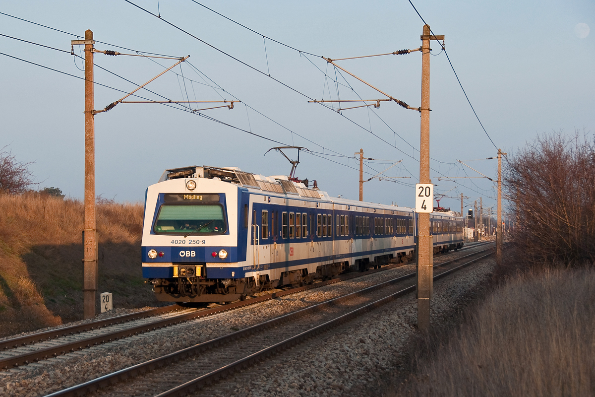 4020 250 mit S-Bahnzug 29615 im Licht der untergehenden Dezembersonne, am 14.12.2013 bei Helmahof. Rechts oben ist übrigens schon der Mond aufgegangen.