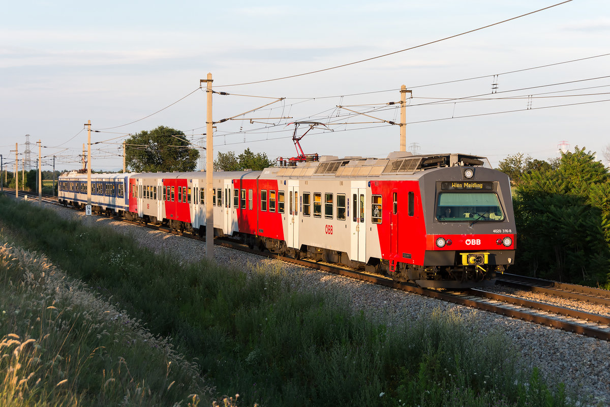4020 316 als Schnellbahnzug auf der Nordbahn in der tiefstehenden Sonne am Abend des 20.07.2020. Die Aufnahme entstand zwischen Deutsch Wagram und Wien Süßenbrunn kurz vor der Wiener Stadtgrenze.