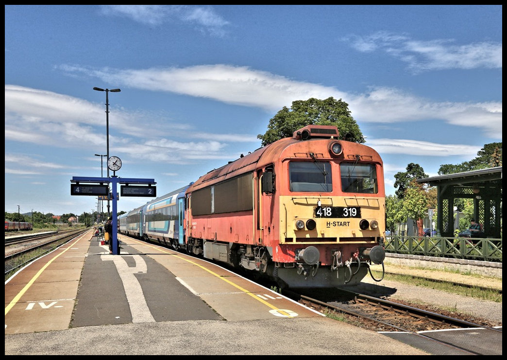418319 steht hier am 14.7.2022 um 13.12 Uhr abfahrbereit mit einem IC nach Budapest auf Gleis 2 im Bahnhof Tapolca. 