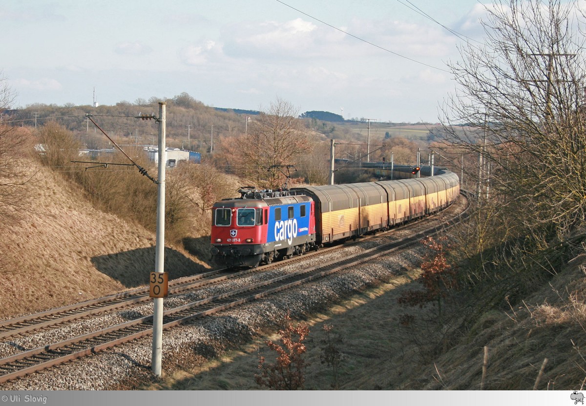 421 377-3 der SBB Cargo befördert einen Autotransportzug von ARS Altmann. Die Aufnahme entstand kurz hinter Neustadt an der Aisch am 12. März 2015.