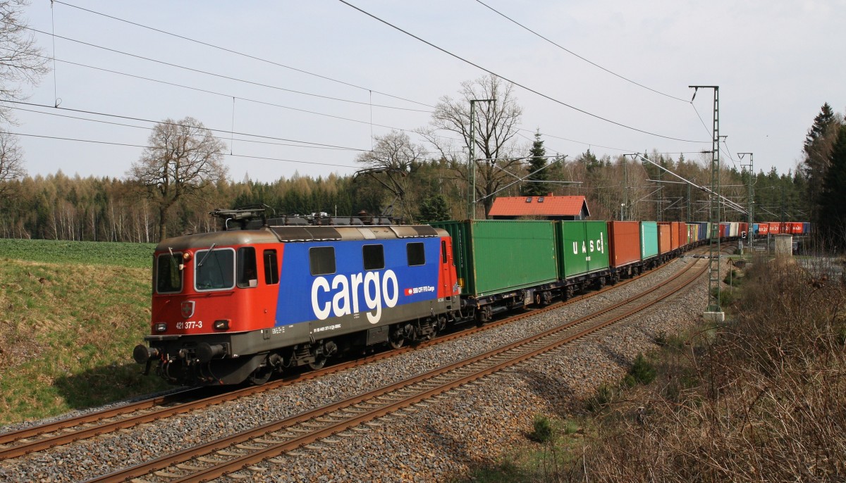 421 377-3 der SBB Cargo ist mit einem Containerzug am 16.4.2015 von Hof Richtung Reichenbach unterwegs. Hier am BÜ bei Schönberg.
