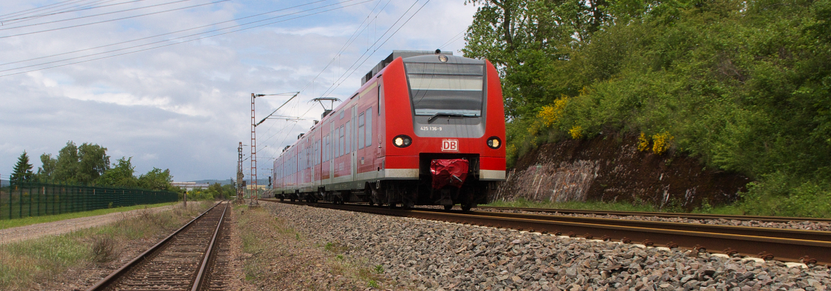 425 136 ist auf der Saarstrecke beim Kraftwerk Ensdorf unterwegs.
Das Anschlußgleis geht nach links über einen Feldweg BÜ zum Kraftwerk Ensdorf.
Das Kraftwerk wird per Schiff mit Importkohle bedient, der Gleisanschluß wird nur genutzt, wenn die Versorgung über Mosel und Saar nicht durchgeführt werden kann.
Bis Anfang 2012 wurde hier regelmäßig Kohle vom 1,5 Kilometern entfernten Bergwerk Ensdorf angeliefert. 12.05.2014 Bahnstrecke 3230 Saarbrücken - Karthaus