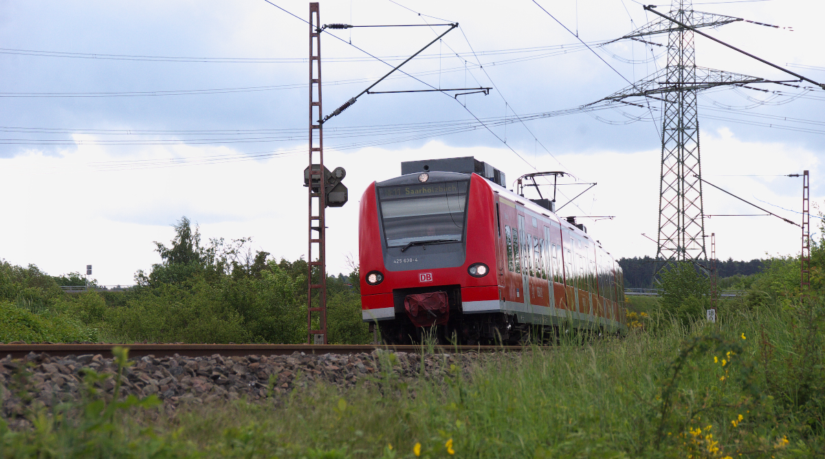 425 138 ist als RE nach Saarhölzbach unterwegs. In Saarhölzbach befindet sich die Grenze zu Rheinland-Pfalz.
Der  Quietschie  hat gerade das Kraftwerk Ensdorf erreicht und biegt in die lange Gerade bis zum Bahnhof Ensdorf ein. Bahnstrecke 3230 Saarbrücken - Karthaus am 12.05.2014 - 