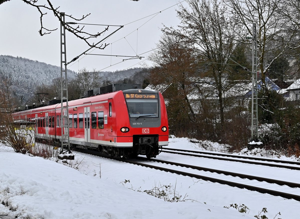 425 713-5 Namens Sinsheim(Elsenz) verlässt im leichten Schneegrieseln Neckargerach als S1 nach Osterburken am heutigen Mittag. Der Zug hat immer noch die Werbeaufkleber für die ausgefallenen Heimattage 2020 in Sinsheim. 26.1.2021
