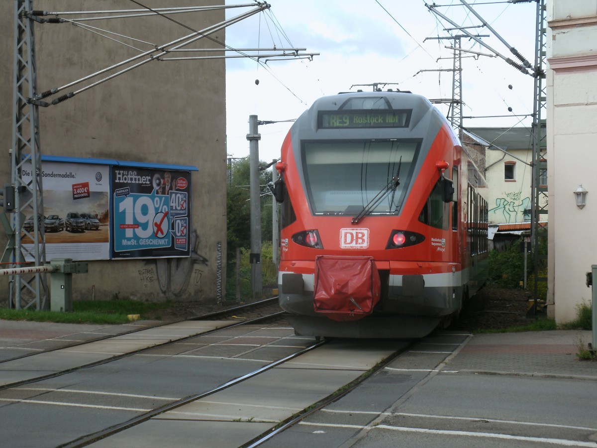 429 026 berquerte,als RE 13008 Sassnitz-Rostock,am 19.September 2013,den Bahnbergang Tribseer Damm an der Ausfahrt aus den Stralsunder Hbf.