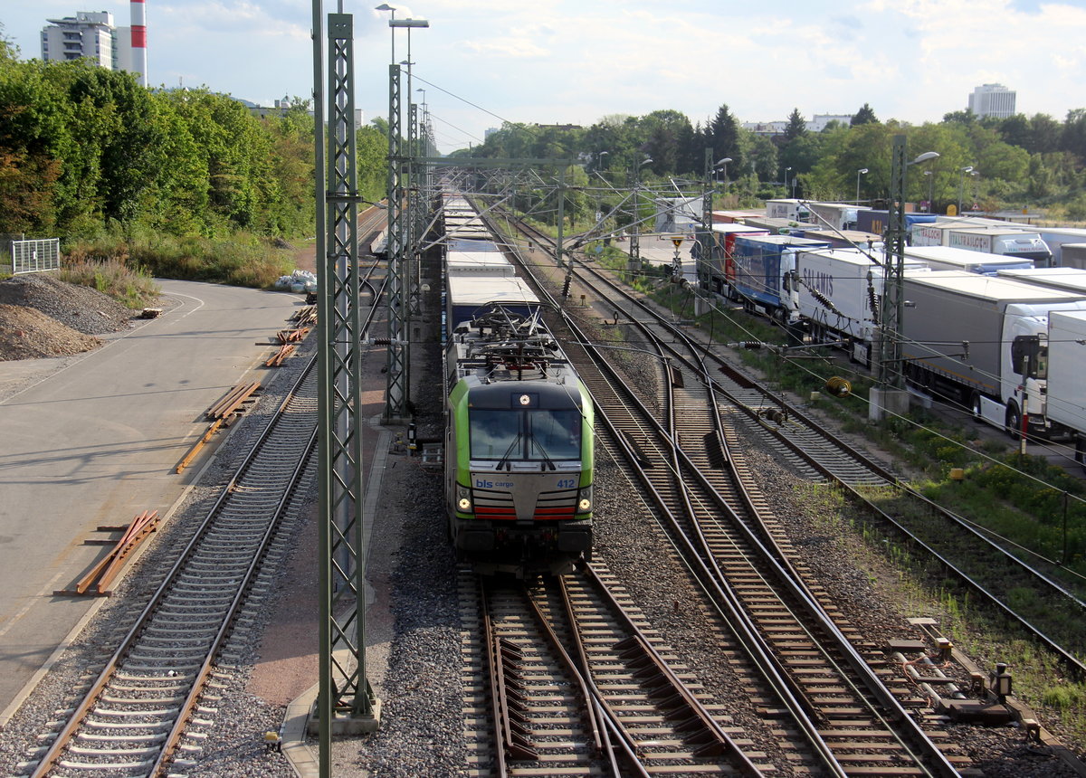 475 412-3 von BLS  kommt mit einem LKW-Zug aus Süden nach Norden  und fährt durch den Güterbahnhof von Freiburg im Breisgau in Richtung Norden. Aufgenommen von der Brücke an der Kaiserstuhlstraße in Freiburg im Breisgau. 
Bei Sommerwetter am 2.8.2019. 