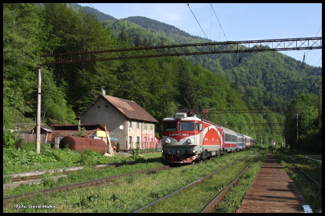 477763-3 fährt hier am 22.5.2015 mit einem Schnellzug aus Sibiu nach Bukarest durch den stark verunkrauteten Landbahnhof Timisul.