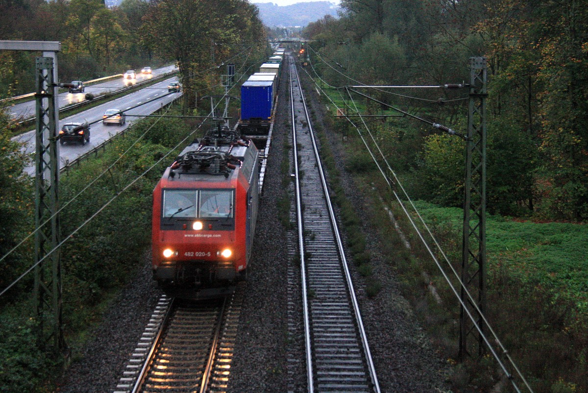 482 020-5 von SBB Cargo  kommt aus Richtung Koblenz mit einem langen Containerzug aus Italien nach Kln und fhrt in Richtung Kln auf der Rechte Rheinstrecke (KBS 465) bei Bad-Honnef am Rhein am einem Regentag im November und in der Abendstimmung am Abend vom 1.11.2013.