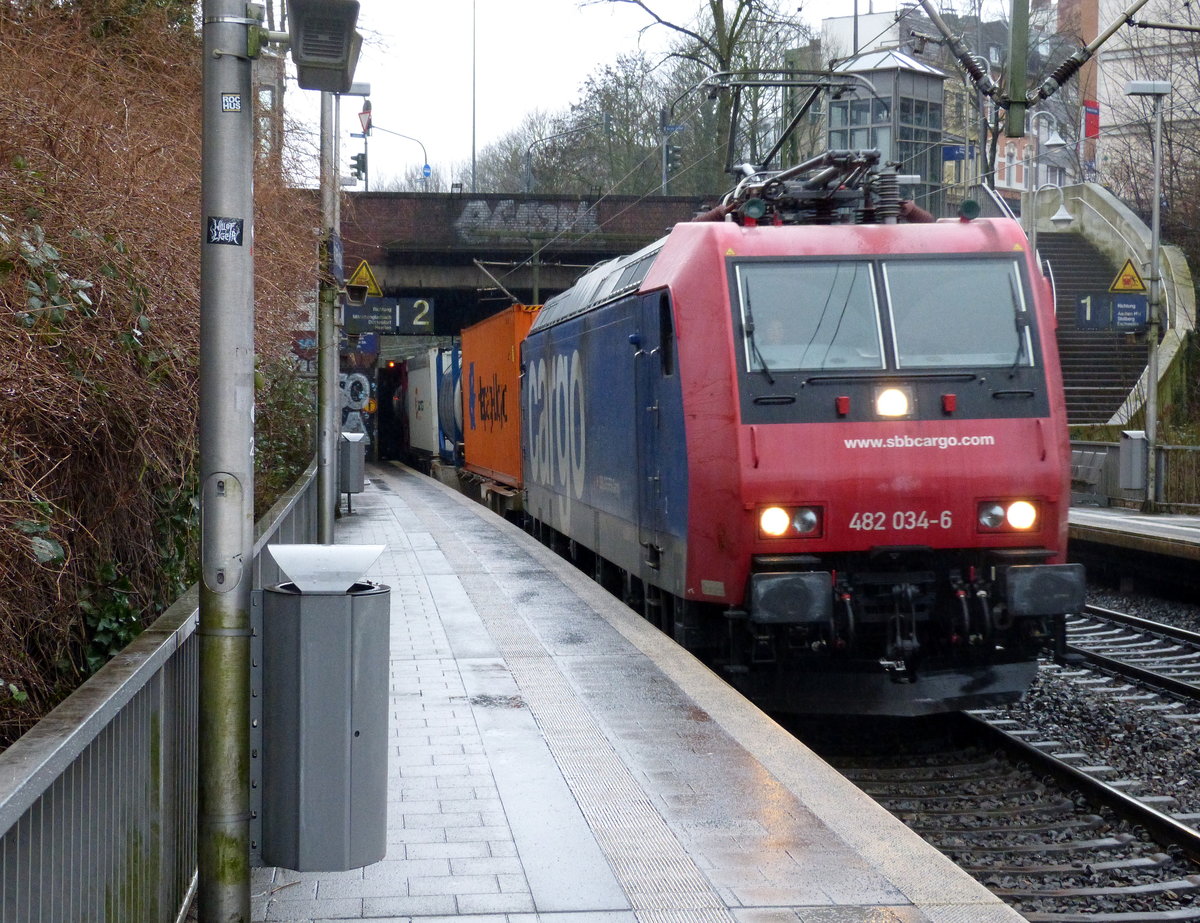 482 034-6 von SBB-Cargo  kommt aus Richtung Köln,Aachen-Hbf und fährt durch Aachen-Schanz mit einem Containerzug aus Gallarate(I) nach Antwerpen-Oorderen(B) und fährt in Richtung Aachen-West. 
Aufgenommen vom Bahnsteig von Aachen-Schanz. 
Bei Regenwetter am Morgen vom 15.2.2018.