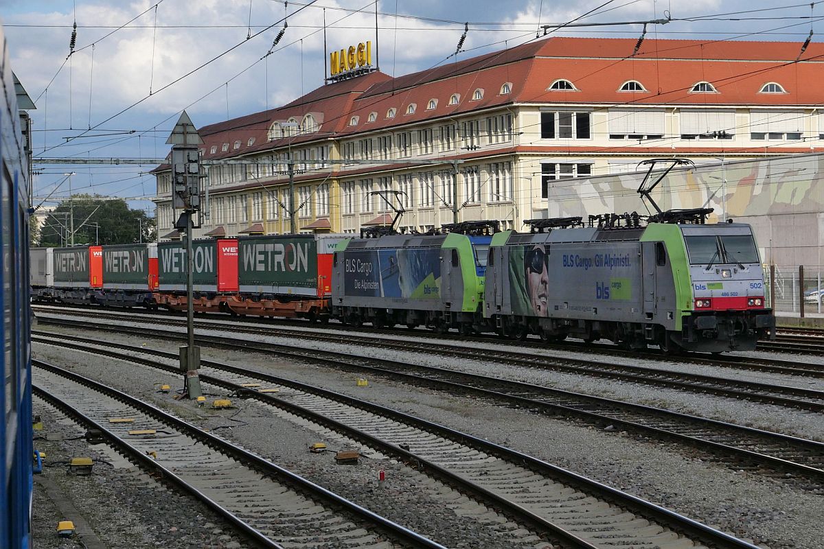 486 502 und eine zweite Lok stehen mit einem KLV-Zug am 27.08.2021 in Singen (Hohentwiel) bereit, um dem ALPEN-SYLT Nachtexpress von Konstanz nach Westerland (Sylt), aus dem diese Aufnahme entstanden ist, im Blockabstand bis Hausach zu folgen