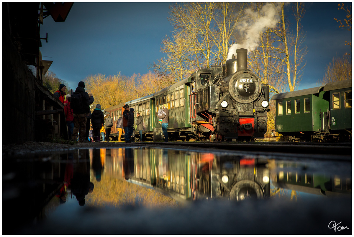 498.04 spiegelt sich in einer Lacke im Bahnhof Grünburg. 
08.12.2018