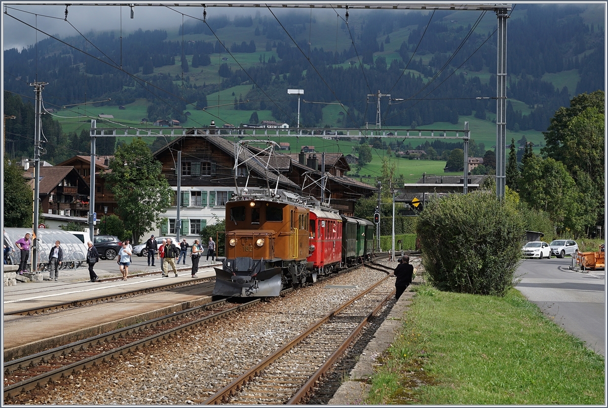 50 Jahre Blonay Chamby - MEGA BERNINA FESTIVAL: der  Bündner Tag im Saaneland : Die RhB Ge 4/4 182 und der RhB ABe 4/4 I 35 warten mit ihrem Zug von Gstaad nach Bulle auf den Gegenzug, die Berninabahn Ge 4/4 82. Der Zug wartet etwas weit hinten, mit Absicht, denn der Gegenzug soll nur bis Ge 4/4 I fahren und damit ein Einmaliges Sujet der drei RhB Fahrzeuge bieten. Auf das genial arrangierte Bild der B-C verzichtet ich jedoch aus verschieden Gründen, vielleicht hat ein anderer BB.de Fotograf doch noch ein Bild davon. 
14. Sept. 2018