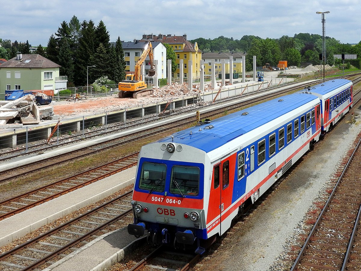 5047 064-0 erreicht im Tandem als R5954 den Bhf. Ried, derweil nebenan das alte Gütermagazin dem Erdboden gleichgemacht wird; 180601